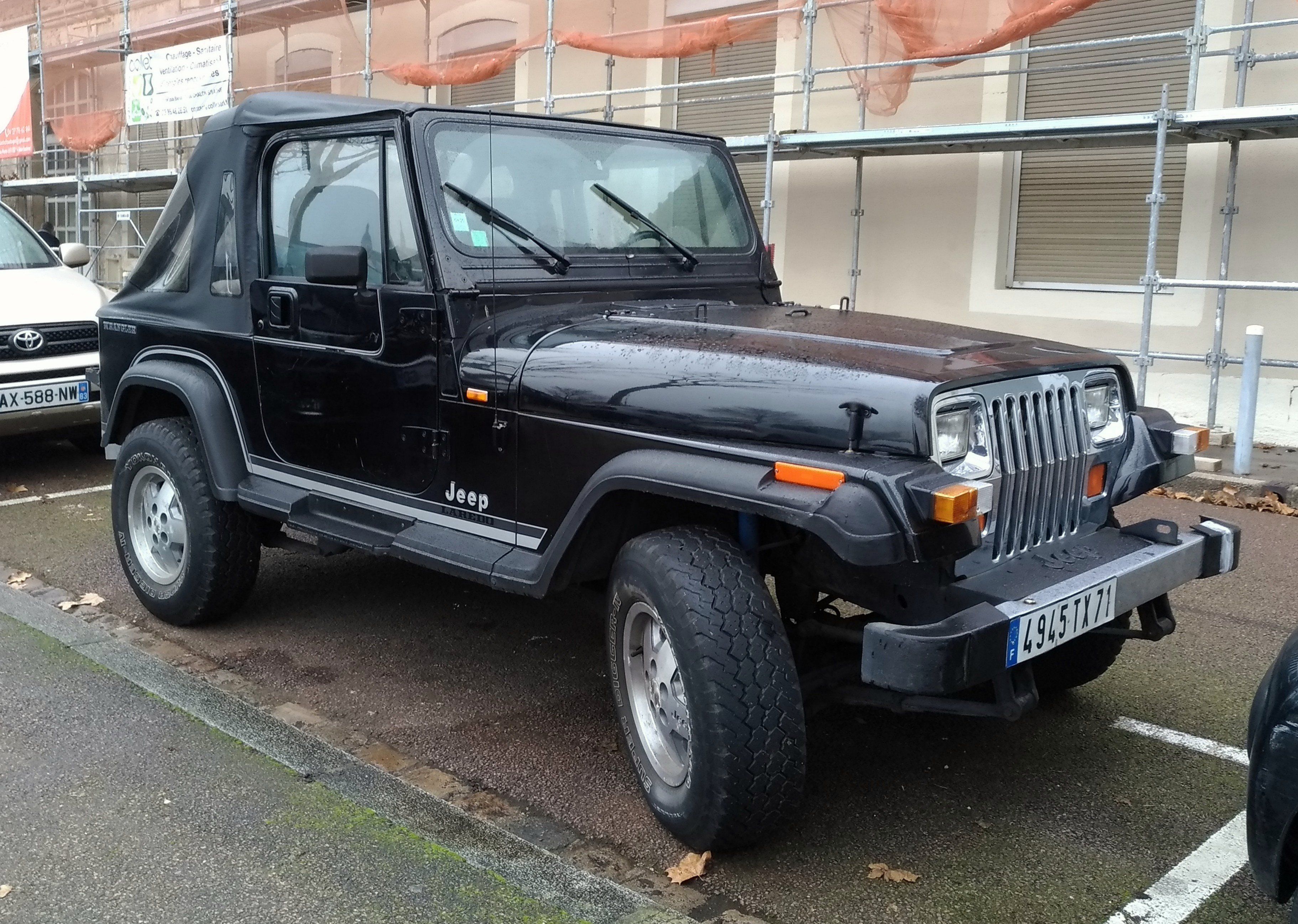 A photo of a black Jeep Wrangler with two doors and a canvas back.